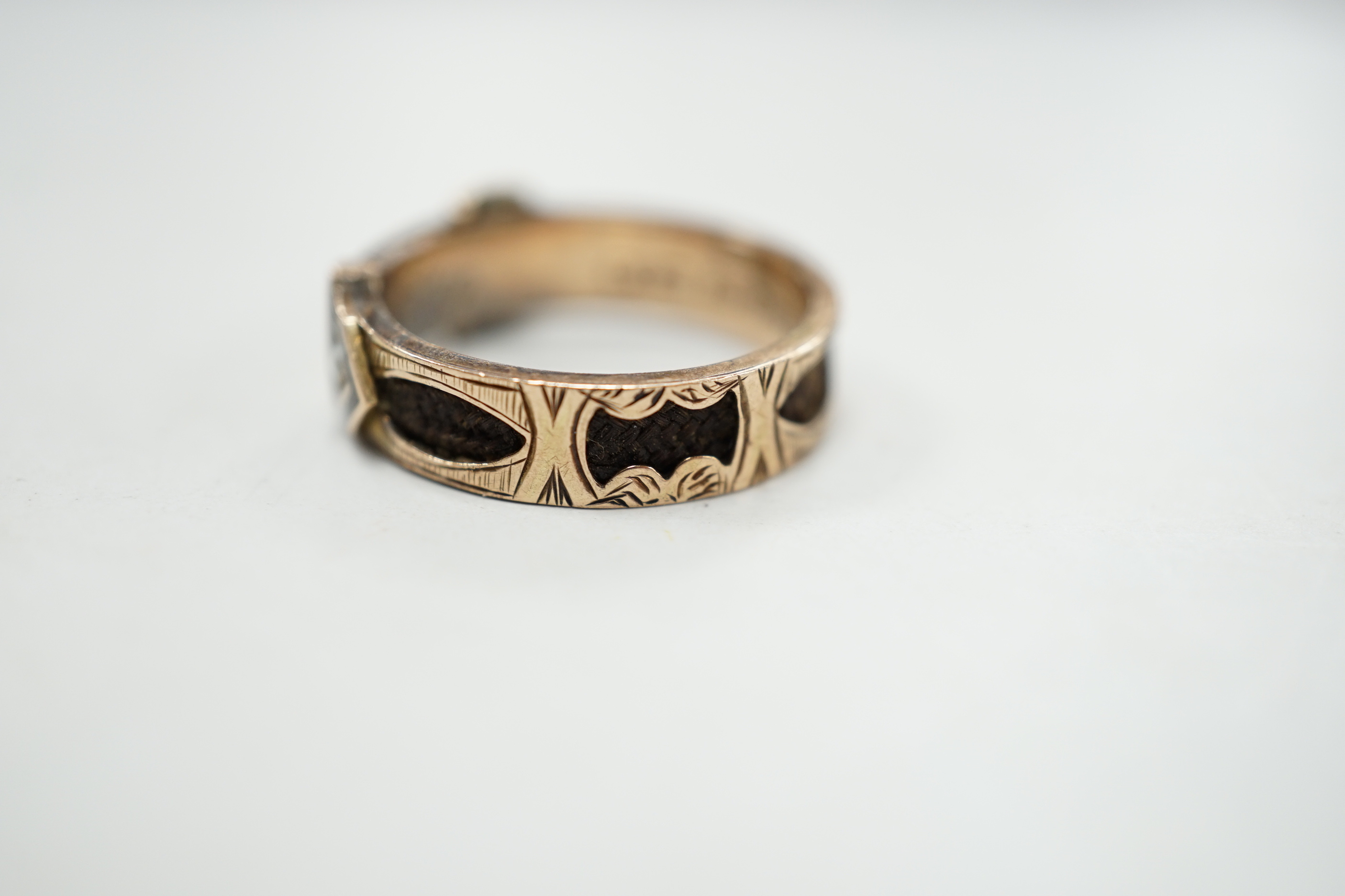 A Victorian 9ct gold, black enamel, plaited hair and seed pearl set mourning buckle ring, size P and a similar yellow metal brooch